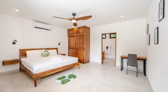 Green Bedroom with shot to bathroom and desk